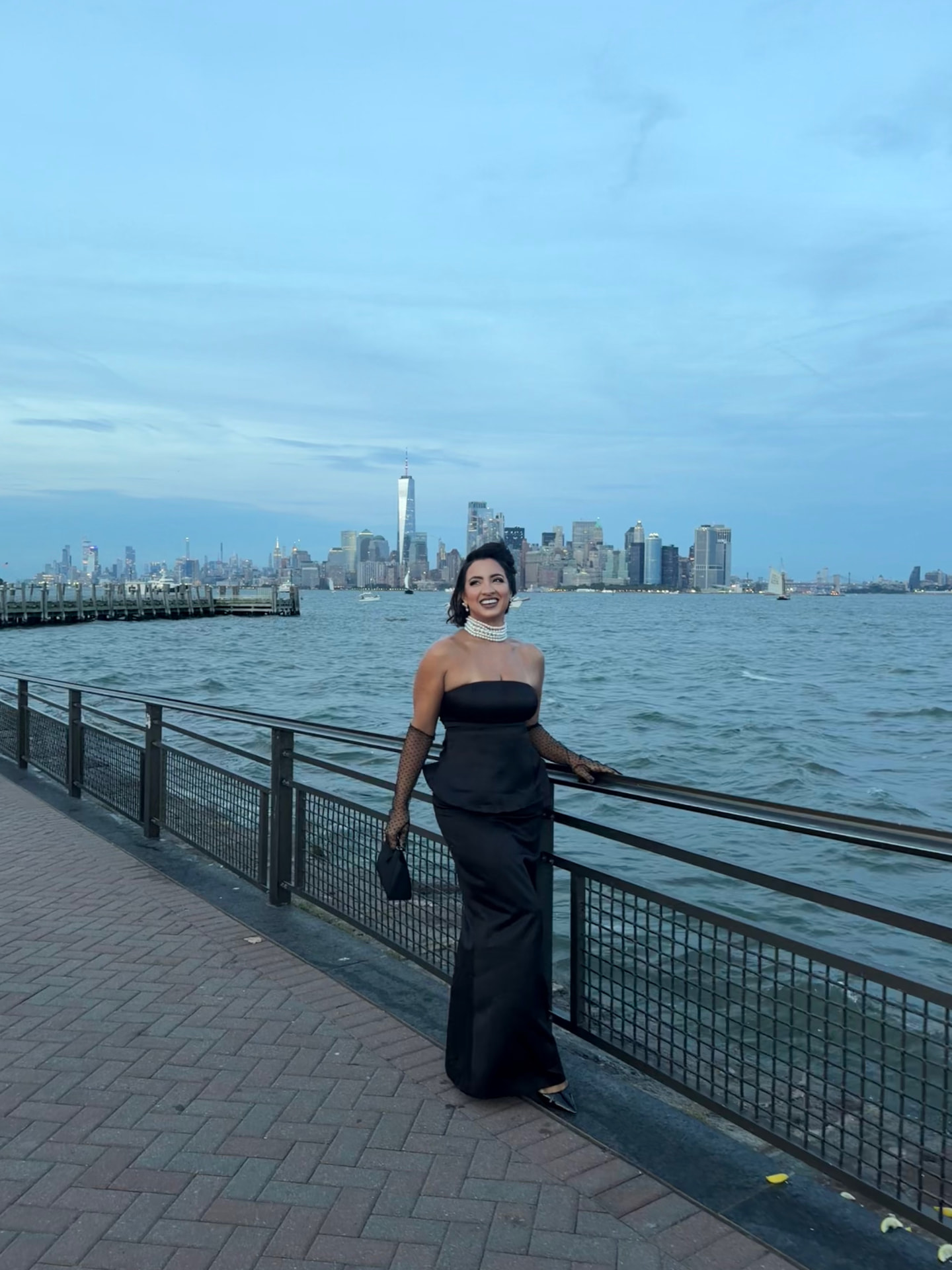 Debora Mendonça in black evening wear against the New York skyline